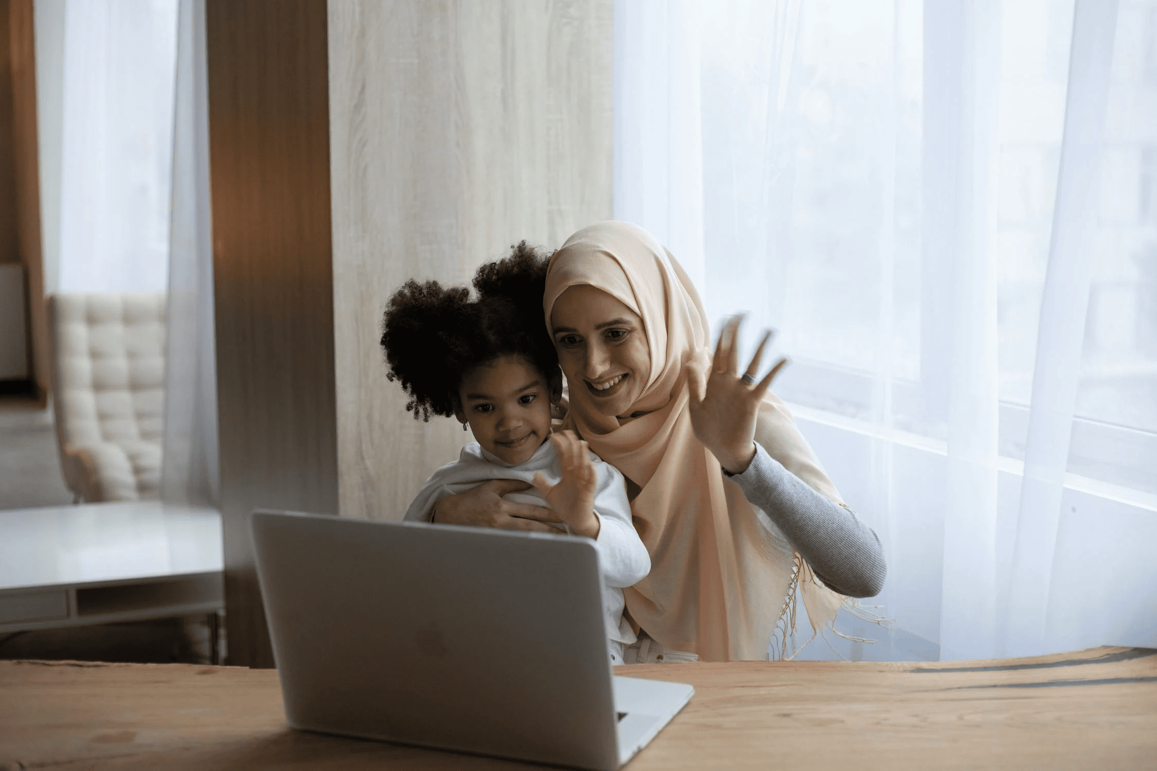 Une femme et un enfant parlent devant un ordinateur